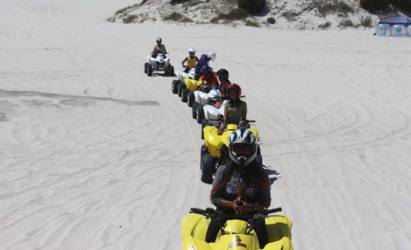 A goup of people enjoying a quad-biking experience from Quadzilla Adventures at Atlantis Dunes