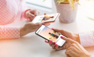 A stock photo of two women using Instagram on their phones