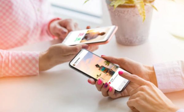 A stock photo of two women using Instagram on their phones