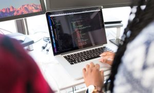 Two people coding on a laptop