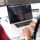 Two people coding on a laptop