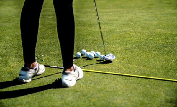 A stock photo of a person playing golf on a golf course
