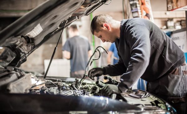 A stock photo of a man servicing a car