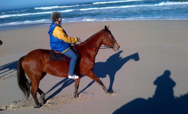 A woman enjoying a horse ride from Patch of Heaven Equestrian Centre in Sir Lowrys Pass